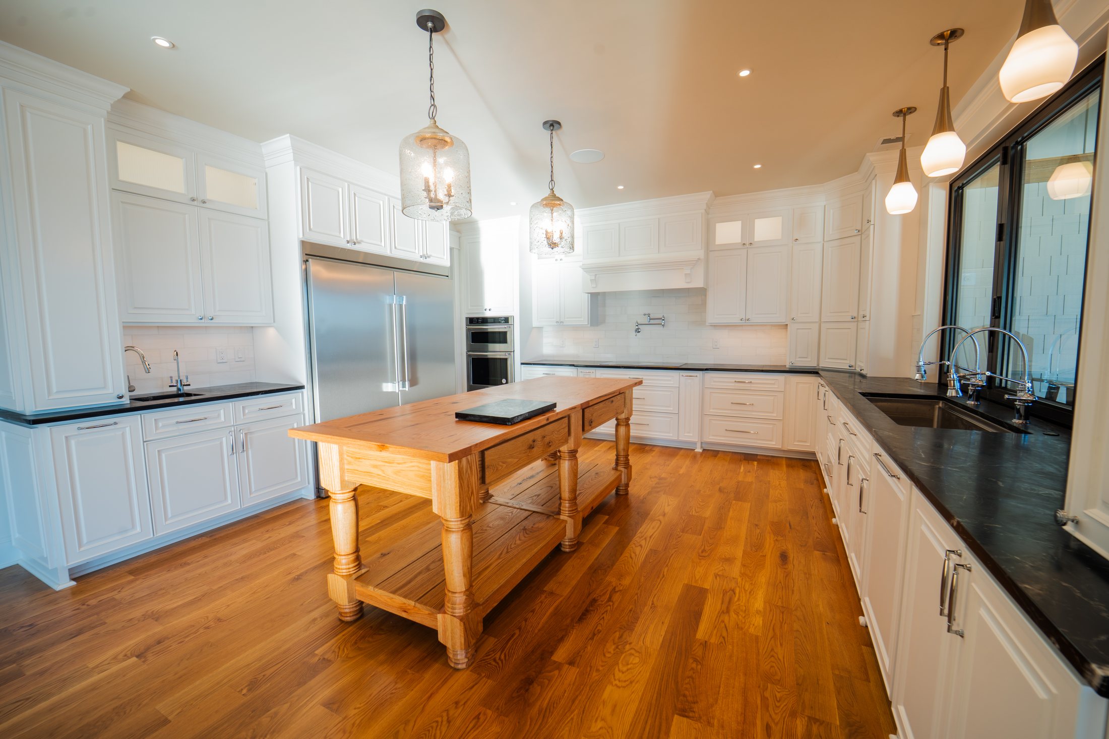 House on the lake kitchen with white millwork and a wood island